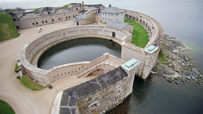 Flygfoto över Kungsholms fort. En fästning och sluphamn byggd av sten.
