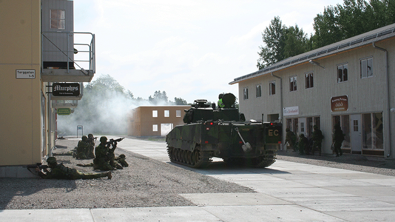 Stridsvagn på en gata i stadsmiljö.