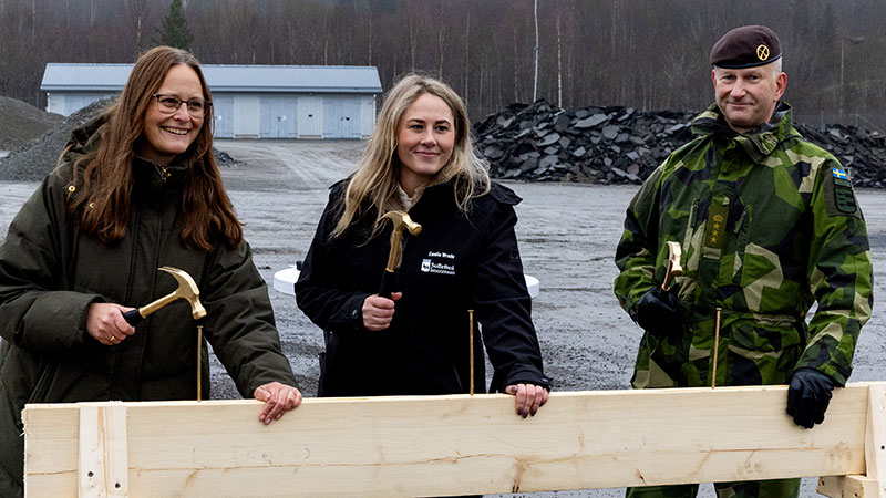 Fortifikationsverkets chef projektavdelningen, Sollefteå kommunstyrelseordförande och regementschef I 21 står med varsin hammare i handen beredd att slå i spikar i en planka.