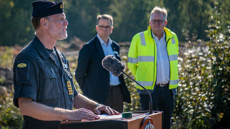 Försvarsmaktens representant står vid ett talarpodium och talar in i en mikrofon
