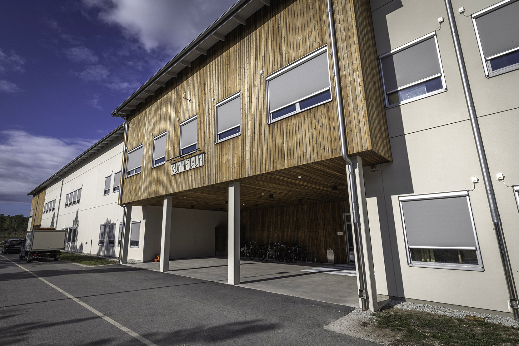 En vit byggnad med trädetaljer mot en blå himmel