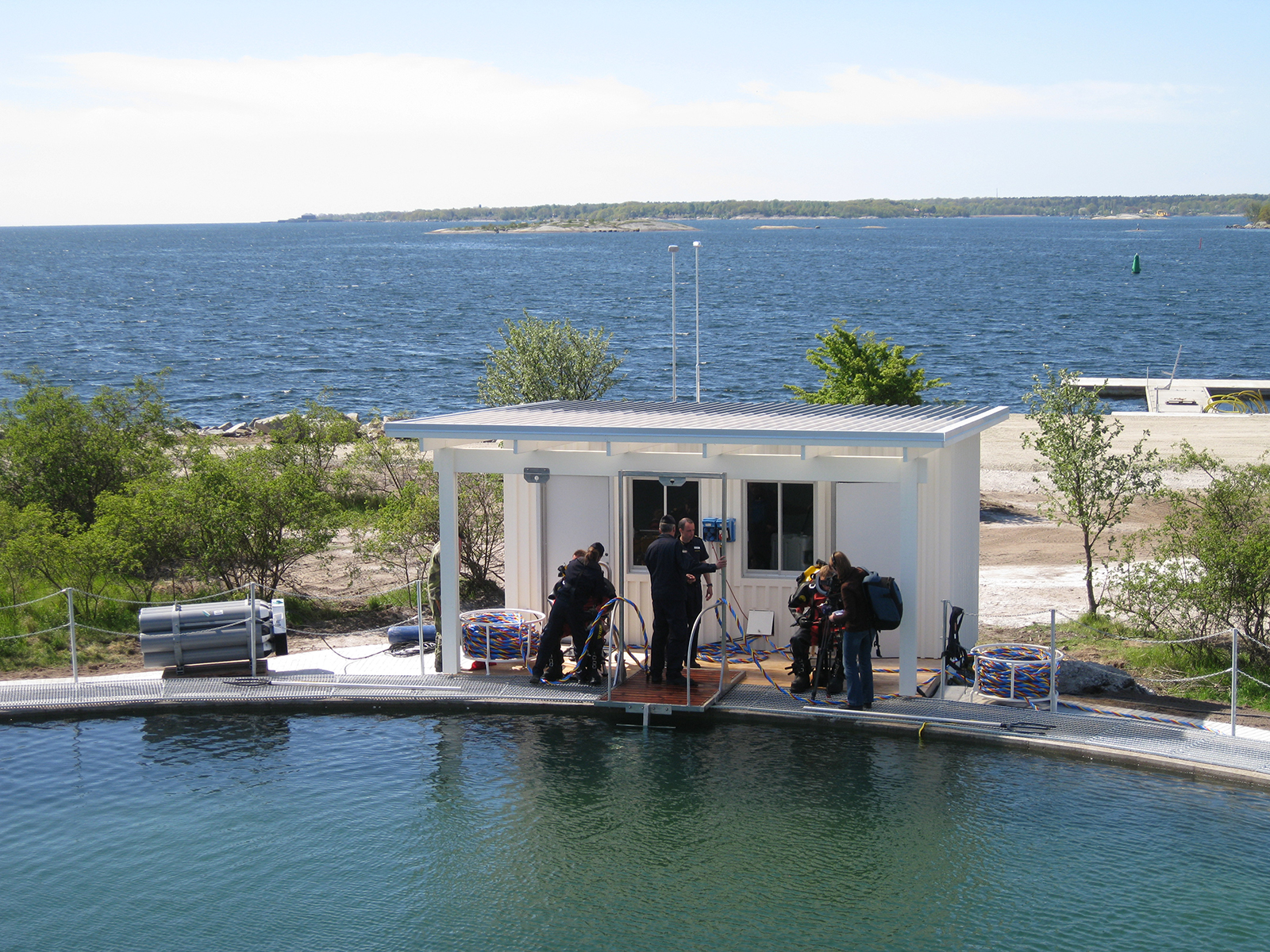 Dykare vid en bassäng med havet bakgrunden