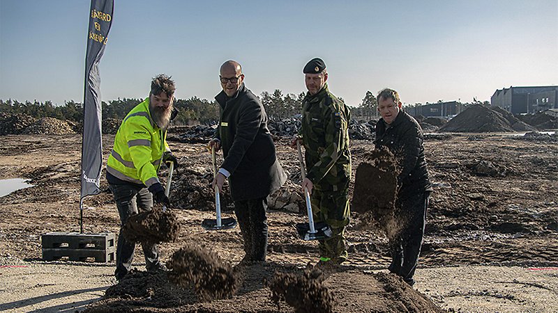 Fyra personer med varsin spade tar ett spadtag.